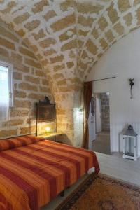 a bedroom with a bed in a stone wall at Masseria Tornesella Don Giuliano in Parabita