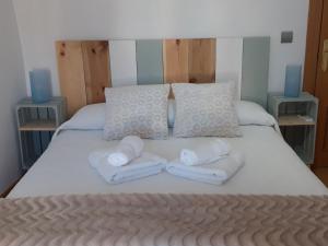 a bed with white towels and pillows on it at Casa rural La tía María in Pereruela