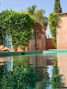 una piscina de agua frente a un edificio en Villa Magtafa en Marrakech