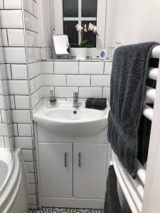 a white bathroom with a sink and a toilet at Trustay Serviced Apartments - Shoreditch in London