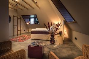 a bedroom with a bed and a table with flowers at Het Spijkerhuys in Luttenberg