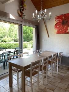 een eetkamer met een houten tafel en stoelen bij Chalet l'Arcange 2 a 6 personnes au calme bord riviere Lison Franche Comte in Nans-sous-Sainte-Anne