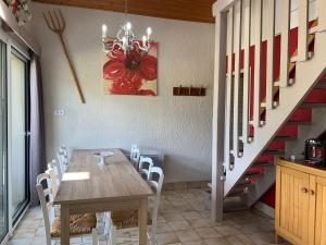 a dining room with a table and chairs and a staircase at Chalet gite l'Arcange 3 chambres au calme Franche Comte bord de riviere peche sur place in Nans-sous-Sainte-Anne +19 photos