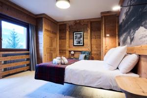 a bedroom with a bed, a chair, and a window at Hotel Europa in Cortina dʼAmpezzo
