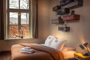 a bedroom with a bed with luggage on the wall at Het Spijkerhuys in Luttenberg
