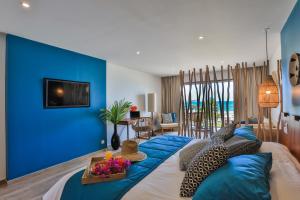 a blue bedroom with a bed with a blue wall at Orient Beach Hotel in Orient Bay