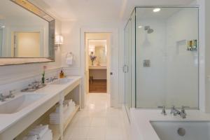 a white bathroom with two sinks and a shower at Chatham Bars Inn in Chatham
