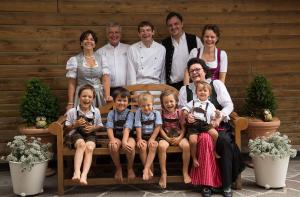 a family posing for a picture on a bench at Berglandhotel Untertheimerhof in Villandro