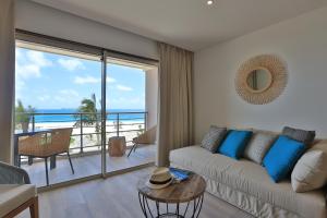 a living room with a couch and a view of the ocean at Orient Beach Hotel in Orient Bay +9 photos