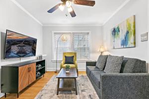 a living room with a couch and a tv at Chicago Local Vibe Residential 1BR Roscoe Village - Marshfield N3 in Chicago