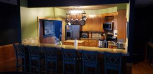 a kitchen with a bar with blue chairs in it at Dances Bay in Elizabeth City