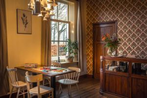 een eetkamer met een tafel en stoelen en een raam bij Het Spijkerhuys in Luttenberg