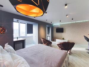 ein Schlafzimmer mit einem großen Bett und Stühlen in der Unterkunft Ayezova 7, LOFT apartment in Öskemen