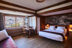 a bedroom with a large bed and a window at Hotel Europa in Cortina dʼAmpezzo