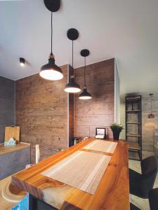 ein Esszimmer mit einem Holztisch und Lampen in der Unterkunft Ayezova 7, LOFT apartment in Öskemen