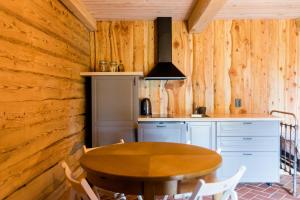 een houten keuken met een tafel en een fornuis bij ETNO house in Ricieliai