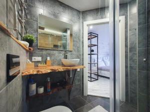 ein Badezimmer mit Waschbecken, Toilette und Spiegel in der Unterkunft Ayezova 7, LOFT apartment in Öskemen + 20 Fotos
