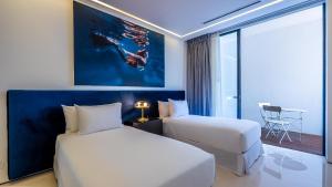 een hotelkamer met twee bedden en een tafel bij PIER 57 - 610 2 BR & Best Sunset Rooftop in PV in Puerto Vallarta