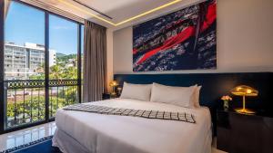 een slaapkamer met een groot bed en een groot raam bij PIER 57 - 610 2 BR & Best Sunset Rooftop in PV in Puerto Vallarta