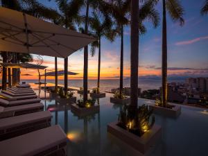 een zwembad met uitzicht op de oceaan bij zonsondergang bij PIER 57 - 610 2 BR & Best Sunset Rooftop in PV in Puerto Vallarta