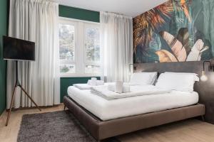 a bedroom with two beds and a painting on the wall at Stay COOPER l Cà de Bezzi in Bolzano