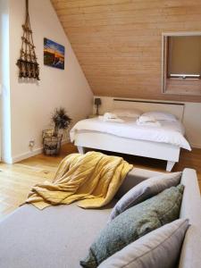 Relax Houses - Domy Mazur في Małkinie: غرفة نوم بسريرين واريكة
