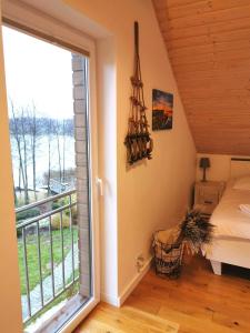 1 dormitorio con ventana, 1 cama y balcón en Relax Houses - Domy Mazur, en Małkinie