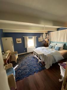 ein Schlafzimmer mit einem Bett und einer blauen Wand in der Unterkunft La Closerie in Durbuy
