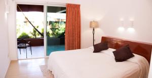 a bedroom with a bed and a sliding glass door at La Ceiba del Mar in Zihuatanejo +31 photos