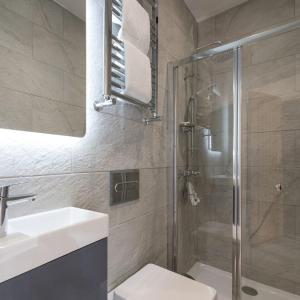 a bathroom with a shower and a sink and a toilet at Coastal Gem Apartment by Seaside Llandudno in Llandudno