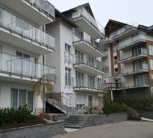 a large white building with stairs in front of it at Apartament Czarna Góra NATALIA in Stronie Śląskie