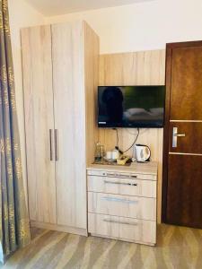 a room with a cabinet with a tv and a tv at Hotel Willa Złota in Karwia