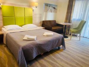 Pokój hotelowy z dużym łóżkiem i krzesłem w obiekcie Hotel Willa Złota w Karwii