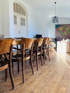 una fila de mesas y sillas de madera en una habitación en The westhouse, en Middelkerke