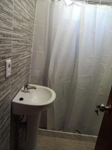 uma casa de banho com um lavatório e uma cortina de chuveiro em CandeYaz em Piriápolis