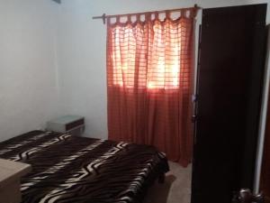 um quarto com uma cama e uma cortina vermelha em CandeYaz em Piriápolis