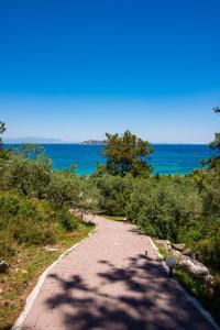 a road with the ocean in the background at Villa Victoria by La Scala Beach in Limenas