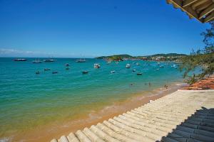 a beach with boats and people in the water at Sofia's on the Beach in Búzios