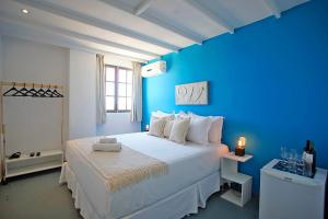 a blue bedroom with a large bed with a blue wall at Sofia's on the Beach in Búzios