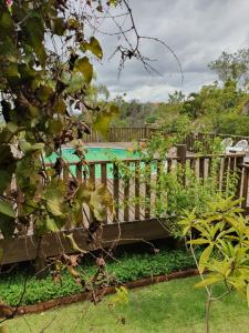 un banco de madera en un jardín con piscina en Reino Solar, en Cunha