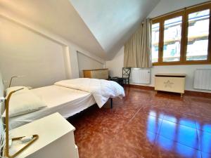 a bedroom with a white bed and a large window at Sol Ski V Atic, apartamento para 12 en Canillo, muy cerca de Sector Tarter in Canillo