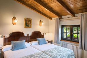 a bedroom with two beds and a window at Casas Rurales El Llugarón in Miravalles