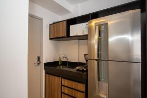 a kitchen with a stainless steel refrigerator and a sink at VNH Residencial by Audaar in São Paulo