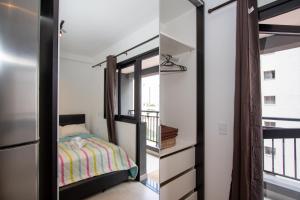 a bedroom with a bed and a balcony at VNH Residencial by Audaar in São Paulo