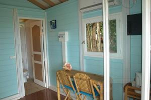 uma casa azul com uma mesa e uma janela em Résidence COCO D'ILES, Gite TI BAMBOU em Terre-de-Bas