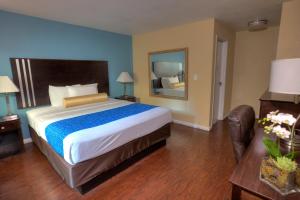 a bedroom with a large bed and a mirror at Sunrise Inn San Diego in San Diego