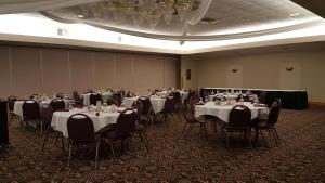 a room filled with tables and chairs with white table cloth at Americas Best Value Inn Chippewa Falls in Chippewa Falls