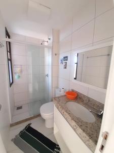 La salle de bains blanche est pourvue d'un lavabo et de toilettes. dans l'établissement Mandara Lanai Porto das Dunas, à Aquiraz