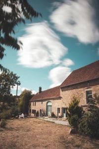 a brick house with a cloudy sky in the background at Le Noyer in Rougnat