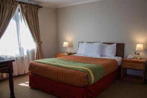 a bedroom with a large bed and a large window at Hotel Diego de Almagro San Pedro De Atacama in San Pedro de Atacama